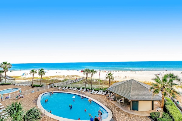 Zona de piscina con sillones de descanso y vista al mar.
