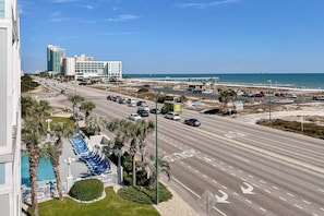 A multi-level hotel with a swimming pool, a parking lot, and a view of the beach and ocean. - Spacious condo near the beach with great view, bonus loft, and shared pool (Orange Beach)