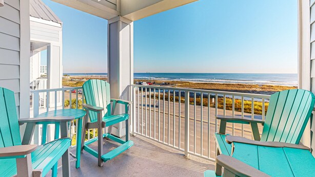 A balcony with chairs and a view of the beach. - Spacious condo near the beach with great view, bonus loft, and shared pool (Orange Beach)
