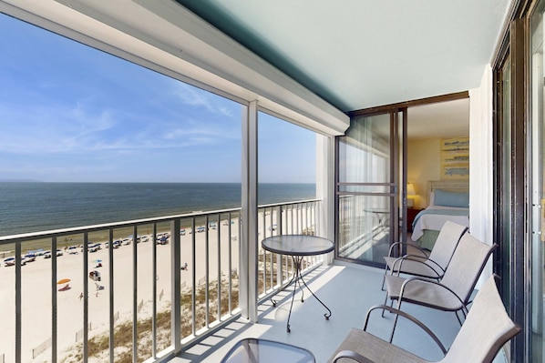 A balcony with a view of the beach and ocean, a table, and chairs. - Recently Updated Beachfront Condo w/ Incredible Views Plus Shared Pools, Hot Tub (Orange Beach)