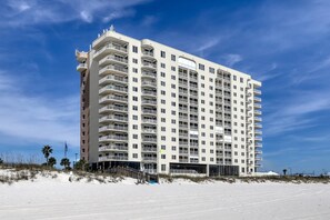 A multi-story hotel with balconies, located near a beach. - Waterfront condo w/ a private balcony, community pools, & fitness center (Orange Beach)