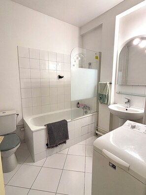A bathroom with a bathtub, toilet, and sink. - L'appartement Blériot (Paris)