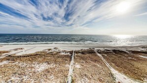 A coastal landscape with a beach, ocean, and a clear sky. - Coastal condo w/ shared, outdoor pool, indoor pool w/ hot tub, & relaxing sauna (Orange Beach)