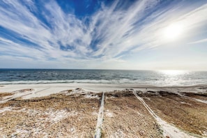 A coastal landscape with a beach, ocean, and a clear sky. - Coastal condo w/ shared, outdoor pool, indoor pool w/ hot tub, & relaxing sauna (Orange Beach)
