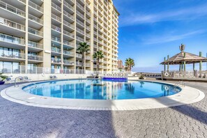 Ein Hotel mit Schwimmbad, mehreren Balkonen und Blick auf den Strand.