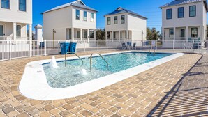A swimming pool with a brick deck, surrounded by white fences and houses. - Friendly home with private pool, WiFi, private washer,dryer, and central AC (Orange Beach)