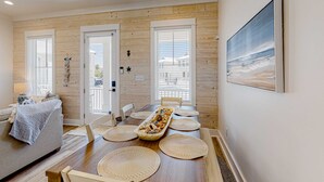 A dining area with a wooden table, woven placemats, and a decorative centerpiece. - Friendly home with private pool, WiFi, private washer,dryer, and central AC (Orange Beach)