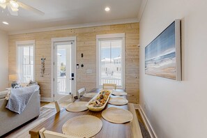 A dining area with a wooden table, woven placemats, and a decorative centerpiece. - Friendly home with private pool, WiFi, private washer,dryer, and central AC (Orange Beach)