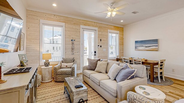 A living room with a sofa, coffee table, and dining area. - Friendly home with private pool, WiFi, private washer,dryer, and central AC (Orange Beach)