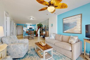 A living room with a sofa, armchairs, a coffee table, a ceiling fan, and a painting on the wall. - Fifth-Floor Getaway in Beachfront Resort with Free WiFi, Central AC, Shared Pool (Orange Beach)