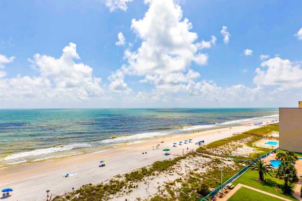 A beach view with a pool and a building. - Gulf-front condo with central AC, balcony & pool (Gulf Shores)