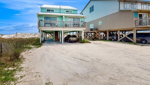 Um imóvel à beira-mar com uma casa de dois andares, varanda coberta e garagem coberta.