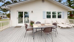 Ein Haus mit einer Terrasse, einem Esstisch und Stühlen sowie einer Patio.