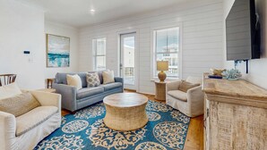 A living room with a sofa, armchairs, a coffee table, and a fireplace. - Brillant cottage near beach with shared pool, balcony, and washer & dryer (Gulf Shores)