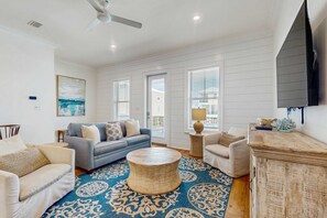 A living room with a sofa, armchairs, a coffee table, and a fireplace. - Brillant cottage near beach with shared pool, balcony, and washer & dryer (Gulf Shores)