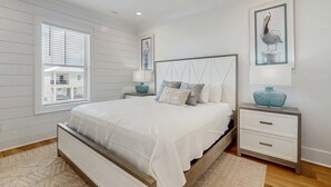A bedroom with a bed, nightstands, a ceiling fan, and artwork on the walls. - Brillant cottage near beach with shared pool, balcony, and washer & dryer (Gulf Shores)