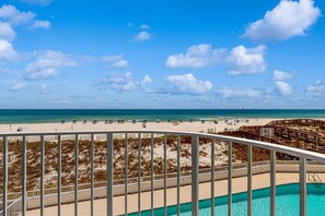 Ein Strandresort mit Pool, Liegestühlen, Sonnenschirmen und einer Holzterrasse.