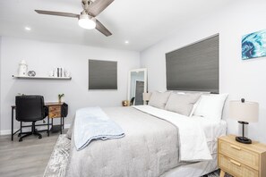 A bedroom with a bed, a desk, a chair, a nightstand, a lamp, a ceiling fan, and a window with blinds. - Mins to the Beaches and Downtown, Backyard Oasis, Serene Neighborhood (Sarasota)