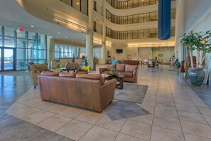 A spacious lobby with leather sofas, a coffee table, and potted plants. - Gulf-front retreat with great view, balcony, pools, lazy river, & hot tubs (Orange Beach)
