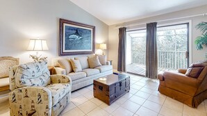 Un salon avec un canapé, un fauteuil et une table basse.