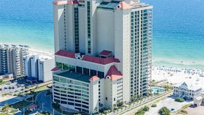 Ein Hochhotel mit mehreren Stockwerken, einem Pool und Blick auf den Strand.
