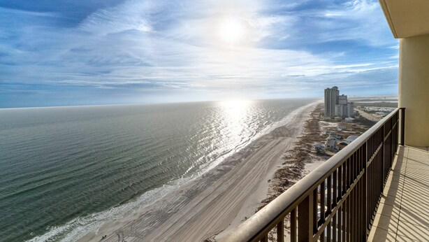 Ein Balkon mit Blick auf Strand und Meer.