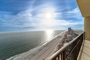 Uma varanda com vista para a praia e o oceano.