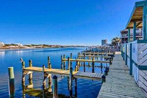A wooden pier extending into calm water, with a building on the right side. - Gulf-front corner condo with wraparound balcony, pools, beach access (Orange Beach)