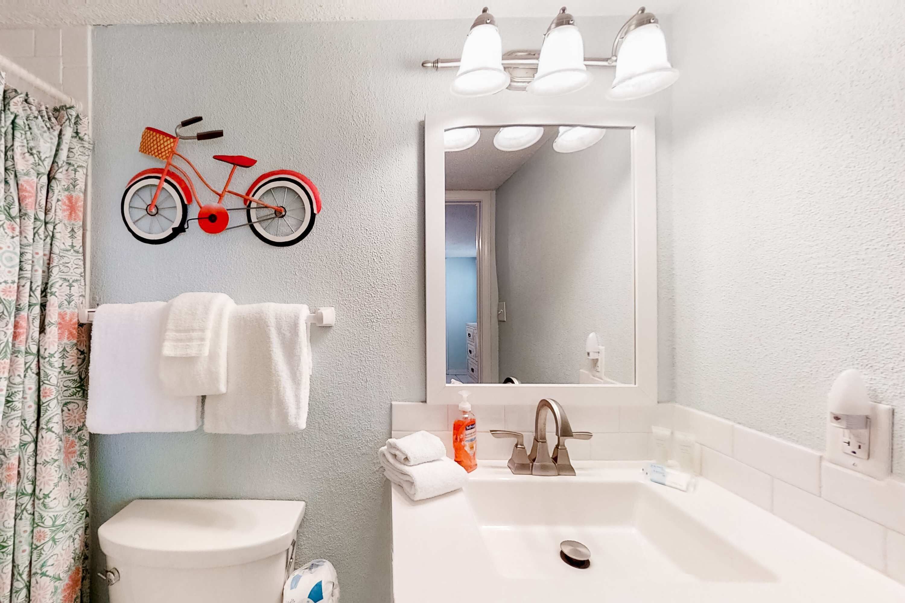 Une salle de bain avec des toilettes, un lavabo et un miroir.