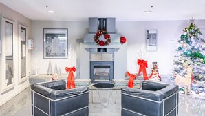 A modern living room with a fireplace, two black leather sofas, a Christmas tree, and holiday decorations. - Modern & Cozy Stay in Prime DT (Vancouver)