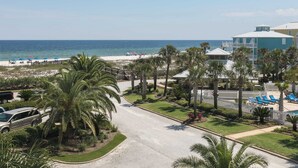 Een resort met uitzicht op het strand, palmbomen en een zwembad.