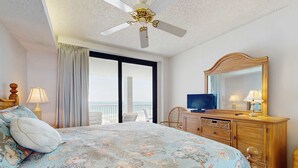 Ein Hotelzimmer mit Bett, Fernseher, Kommode und einem Balkon mit Blick.