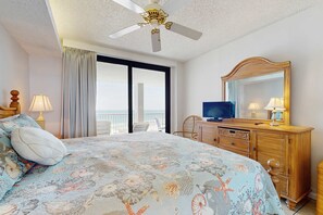 Ein Hotelzimmer mit Bett, Fernseher, Kommode und einem Balkon mit Blick.