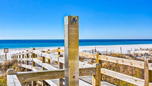 A wooden boardwalk leading to a beach with a clear blue sky. - Spacious condo with Gulf-front views & access to pools, hot tub, gym (Orange Beach)