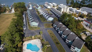 An aerial view of a coastal hotel with multiple buildings, a swimming pool, and a marina. - Calming water view condo with full kitchen, balcony, pool, & TV - close to park (Orange Beach)