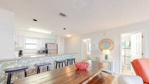 A modern kitchen with white cabinets, a microwave, and a refrigerator. - Calming water view condo with full kitchen, balcony, pool, & TV - close to park (Orange Beach)