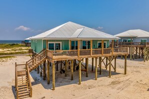 Ein Strandhaus mit Holzterrasse und Meerblick.