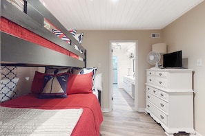 A bedroom with a bunk bed, a dresser, a TV, and a fan. - Bayfront home with boat dock, water views, deck, & fish cleaning station (Dauphin Island)