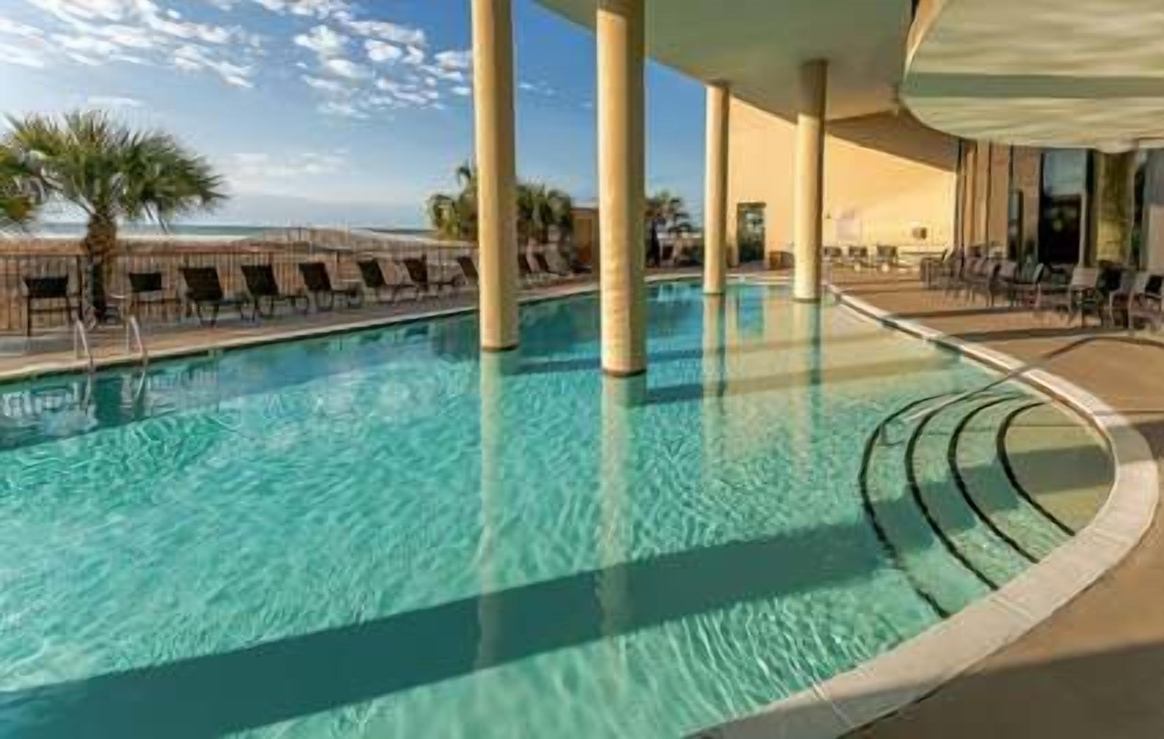 Una piscina con lettini e vista sull'oceano.