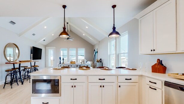 A spacious kitchen with a central island, pendant lighting, and a large window. - Cadillac Margarita, House in Dauphin Island (Dauphin Island)