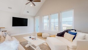 A spacious living room with a ceiling fan, a flat-screen TV, and large windows. - Cadillac Margarita, House in Dauphin Island (Dauphin Island)