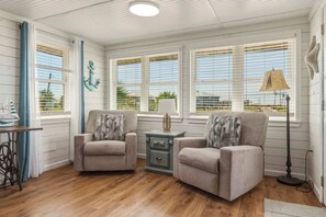 A room with two armchairs, a small table, a lamp, and a decorative anchor on the wall. - Dog-friendly house on Dauphin Island, Near beach access, Patio, Grill, Washer & Dryer (Dauphin Island)
