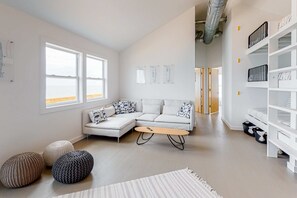 Una sala de estar moderna con un sofá modular, una mesa de centro y una estantería blanca.