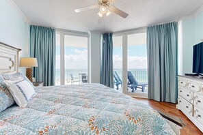 A bedroom with a large bed, a ceiling fan, a dresser, and a view of the balcony. - Beachfront Condo with Gulf View & Shared Pools & Hot Tubs - Snowbirds Welcome (Gulf Shores)