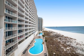 A hotel with multiple balconies, a swimming pool, and a beach view. - Beachfront Condo with Gulf View & Shared Pools & Hot Tubs - Snowbirds Welcome (Gulf Shores)
