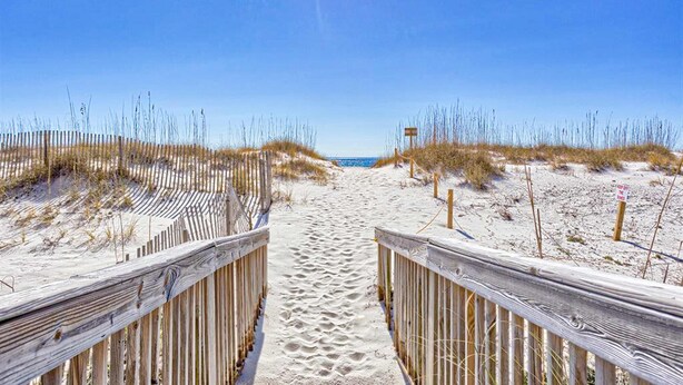 A sandy beach path with wooden railings, leading to the ocean. - Beachfront Balcony with Million-Dollar Views, Shared Pool, WiFi, Washer & Dryer (Gulf Shores)