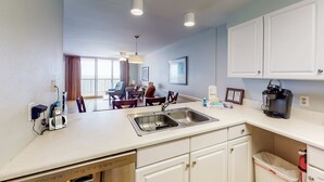 A modern kitchen with a built-in dishwasher, a sink, and a coffee maker. - Beachfront Balcony with Million-Dollar Views, Shared Pool, WiFi, Washer & Dryer (Gulf Shores)