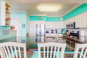 A kitchen with white cabinets, a stainless steel refrigerator, a microwave, and a sink. - Dog-Friendly & Attractive Beach House w/Private Pool, Free WiFi, Central AC (Gulf Shores)