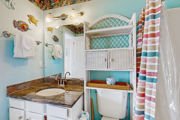 A bathroom with a sink, mirror, towel rack, and a shower curtain. - Lofty Condo in a Beachside Complex w/ WiFi, AC, Balcony & Shared Outdoor Pool (Gulf Shores)