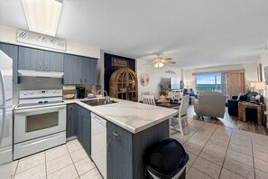 A modern kitchen with a large island, a dining area with a view, and a cozy living space. - Waterview condo with shared pool, panoramic balcony views, and WIFI (Gulf Shores)